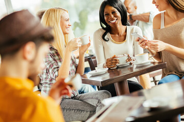 Group of friends enjoying coffee and conversation at cafe