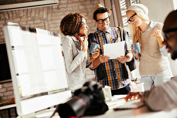 Multicultural creative team discussing project in modern office