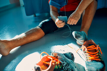 Male athlete setting up playlist on smartphone after intense workout