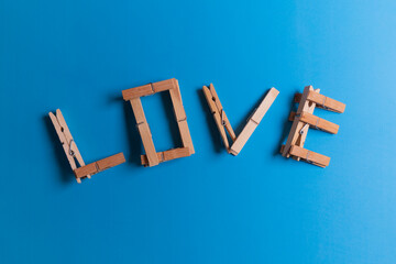 Love written with clothespins, blue background, clothespins, texture