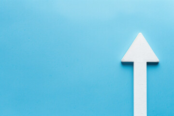 White arrow pointing upwards against a blue background, symbolizing success, growth, and reaching a target in finance and business
