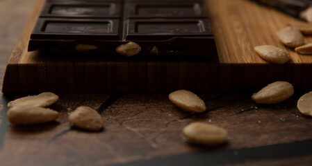 Tableta de chocolate negro con almendras sobre madera