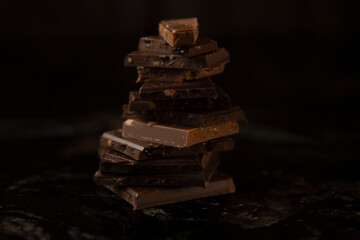 Trozos de tabletas de chocolate en fondo negro