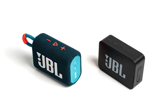 Lyon, France - February 6, 2024: Top down view of two JBL Bluetooth portable speaker models Go 2 and 3, isolated on white background with buttons visible; comparison new and old models JBL speakers.