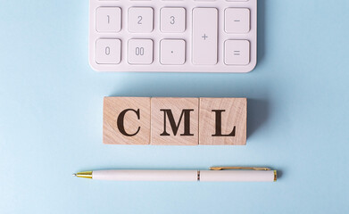 CML-CAPITAL MARKET LINE word on wooden block with pen and calculator on blue background