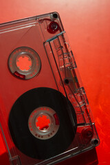 Audio cassette on a blurred red background.