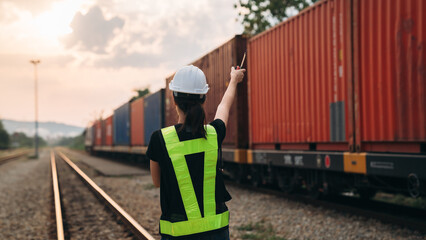 Supervisor inspecting inventory or task information on freight train cars and shipping containers....