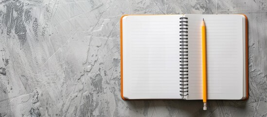 Top view of an open notebook with a pencil on a gray background, school notebooks with a spiral spring, office notepad in a flat lay arrangement.