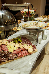 Table decorated with food and salads. Plenty of food on the table. Business event with a table full of food and salads. Catering table full of tasty food.
