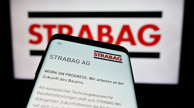 Stuttgart, Germany - 04-15-2024: Mobile phone with logo of Austrian construction company Strabag SE in front of business website. Focus on top-left of phone display.