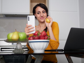 Woman make a pictures of strawberries at home kitchen
