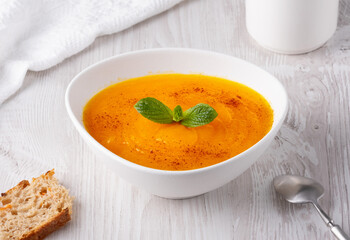 Pumpkin soup on a white wooden table