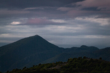 Beautiful view of the mountains and the dark cloudy sky after sunset.