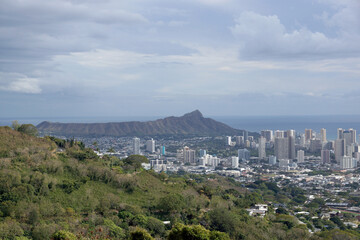 Obraz premium Panoramic View of a Bustling City Skyline Against a Mountainous Backdrop at Dusk