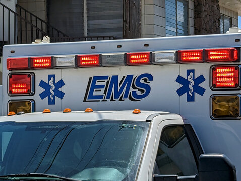 Close-Up View of EMS Ambulance With Flashing Lights During Daytime Emergency Response