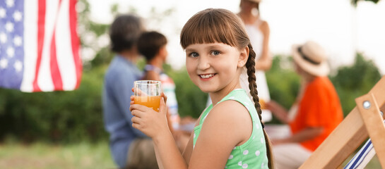 Little girl with her family at barbecue party on summer day