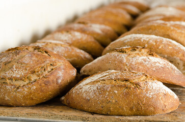 Freshly baked sourdough bread with a golden crust straight from the bakery oven. Display.