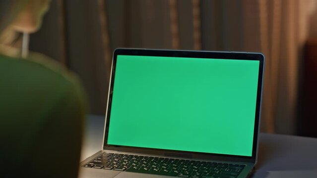 Late worker looking chroma key laptop working on project remotely close up.