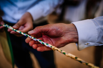Valmiera, Latvia - August 19, 2023 - Close-up of hands holding a braided rope, with focus on the...
