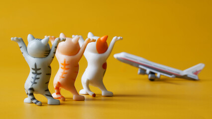 Toy kittens with raised legs and passenger airplane on yellow background. Greeting arriving...