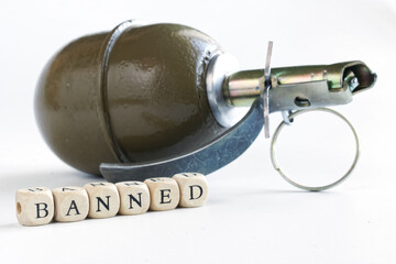 Hand grenade next to the inscription banned on wooden cubes. White background. Concept of banned...