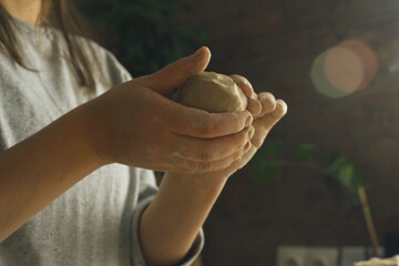 A woman makes a craft from clay