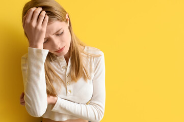 Young woman with brain concussion on yellow background