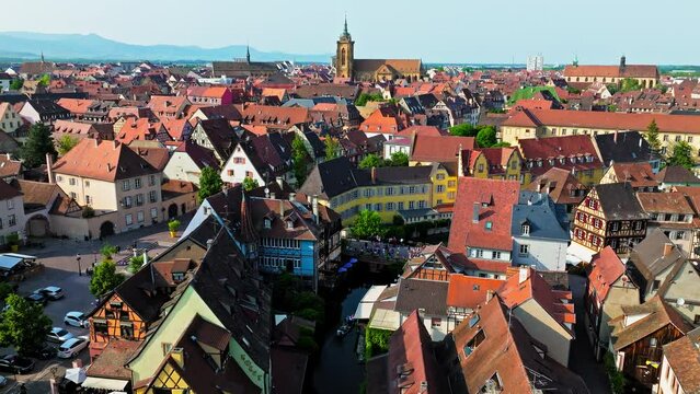 Aerial view of Le Petite Venise Alsatian half-timbered houses along riverbanks in Colmar. Tourists visit the Historical landmark Little Venise by the bridge with colourful houses in Colmar, France.