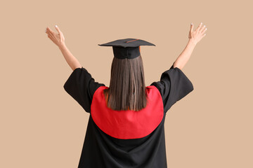 Cheerful female graduate on beige background, back view
