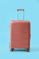 Pink suitcase on blue background