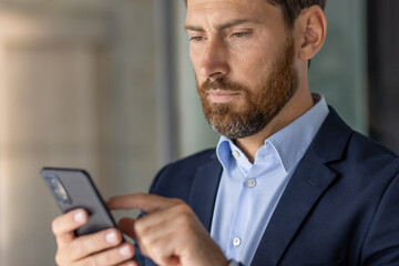 Professional man using smartphone in modern office setting