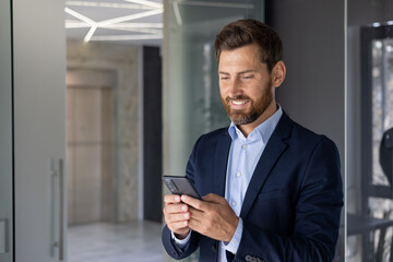 Businessman using smartphone in modern office space