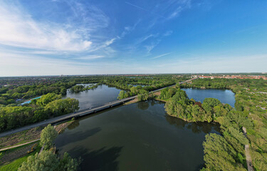 Aerial view of serene lake, trees, and bridge in beautiful natural landscape Hanover Ricklinger Teiche Germany