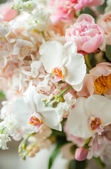 Beautiful wedding bouquet of orchids and peonies with silk ribbons