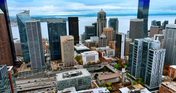 Beautiful lively modern downtown of Seattle. Drone footage distancing from gorgeous buildings and busy highway. Lake Washington at backdrop.