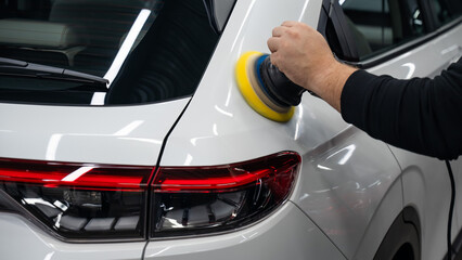 Process of polishing white car body surface using orbital polishing machine. 