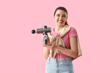 Young woman holding percussive massager with bow on pink background