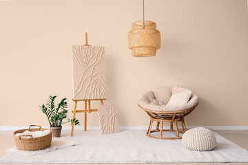 Interior of beige living room with easel, picture, armchair and houseplant