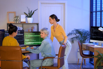 Team of female programmers working in office at night