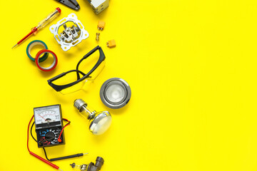 Electrician's tools, light bulbs and electronics on yellow background