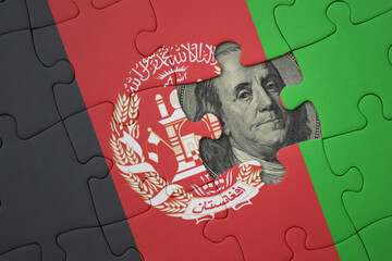 puzzle with the national flag of afghanistan and usa dollar banknote. finance concept