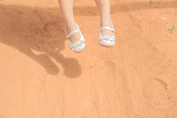 Little girl feet while she is in the swing