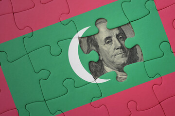 puzzle with the national flag of maldives and usa dollar banknote. finance concept