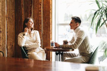 Two People Engaged in Casual Conversation at a Cozy Cafe During the Day