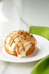 Cinnamon roll bun with icing on plate