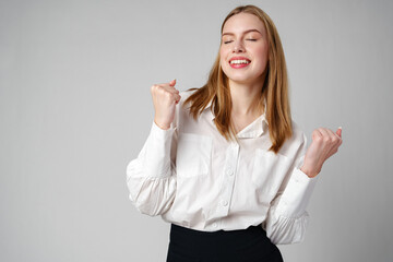 Jubilant Young Woman Celebrating a Victory With a Raised Fist in Studio