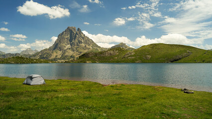One tent near beautiful mountain lake in Pyrenees (Lacs d' Ayous), camping on popular hiking route, France
