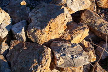 Red rocks of different shapes and sizes on the ground. Orange texture. Background. For text. For...