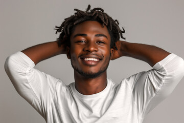 Smiling black man with dreadlocks holding head, wears white sweatshirt against white background - Powered by Adobe