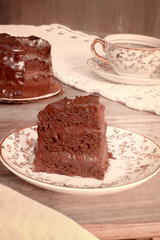 Slice of Little Chocolate Cake with Chocolate Ganache on a Plate with Tea. Tea Time